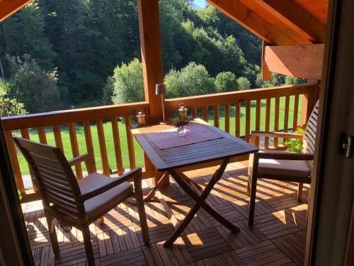 eine Holzterrasse mit einem Tisch und 2 Stühlen in der Unterkunft Landhaus Constantin Luxus-Appartments in Berchtesgaden