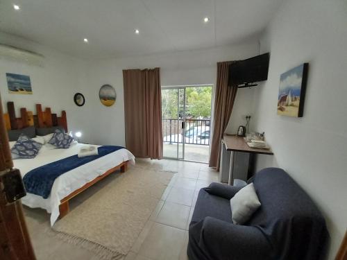 um quarto com uma cama, uma televisão e um sofá em 7 On Grey Guesthouse em Colesberg