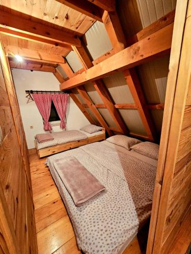 een slaapkamer met een bed in een houten huis bij Vikendica Mateo in Blidinje