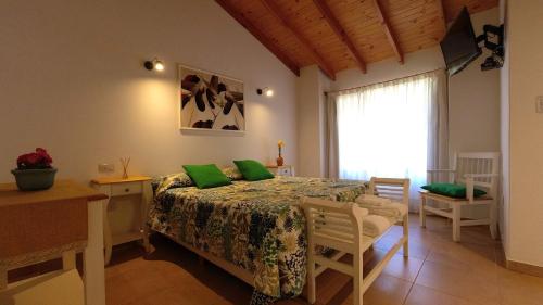 una camera da letto con un letto con cuscini verdi di ANIDO Cabañas y Monoambientes a Lago Puelo