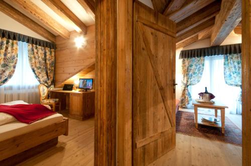a bedroom with a wooden wall with a wooden door at Hotel Gianna in Madonna di Campiglio