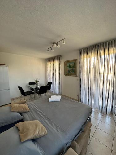 - une chambre avec un grand lit et une table avec des chaises dans l'établissement Monaco Border, Terrace, Sea view & Parking, à Beausoleil