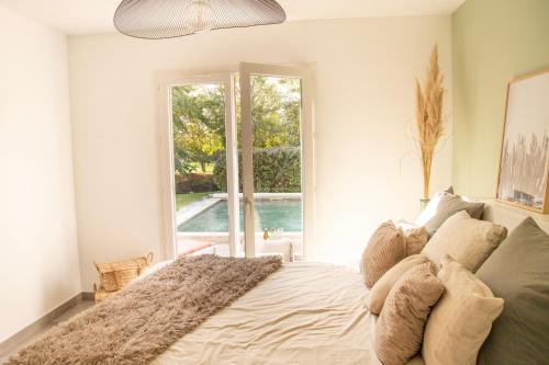 une chambre avec un lit et une grande fenêtre dans l'établissement Maison Loutina, Villa 5 min à pied du centre, à LʼIsle-sur-la-Sorgue