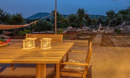 a wooden table and chairs with a view of the mountains at Mourelo Home in Gavalochori