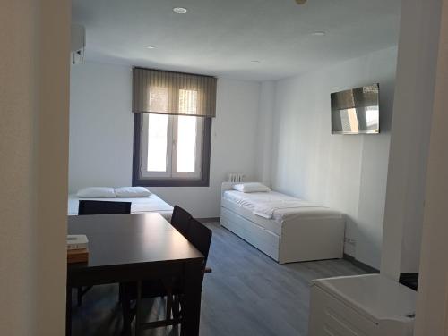 een woonkamer met 2 bedden en een tafel bij Estudio en Callao, 4 personas in Madrid