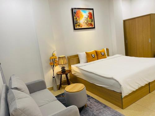 a small bedroom with a bed and a couch at Shogun Hotel in Ho Chi Minh City
