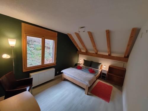 ein kleines Schlafzimmer mit einem Bett und einem Fenster in der Unterkunft Traumhafte Villa Seelisberg in Seelisberg