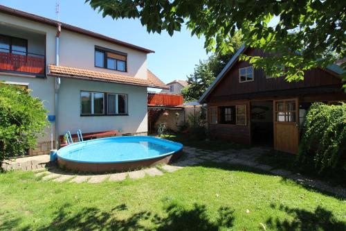 a backyard with a swimming pool in front of a house at Penzion Petra in Telč