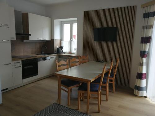 eine Küche mit einem Tisch und Stühlen im Zimmer in der Unterkunft Appartements Stadt Wien in Bad Hofgastein