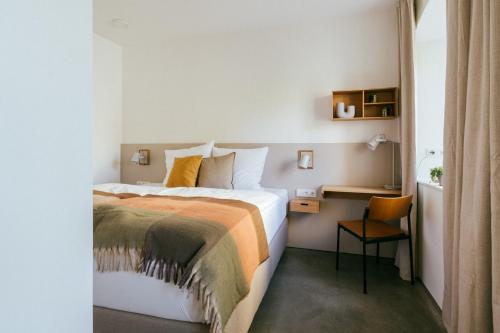 a hotel room with a bed and a desk at STADTQUARTIER Windischeschenbach in Windischeschenbach