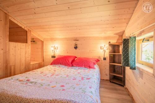 1 dormitorio con 1 cama en una cabaña de madera en Les inseparables, en Saint-Pierre-de-Curtille