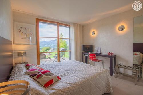 a bedroom with a bed and a window and a desk at Les perrelles in Bellecombe-en-Beauges
