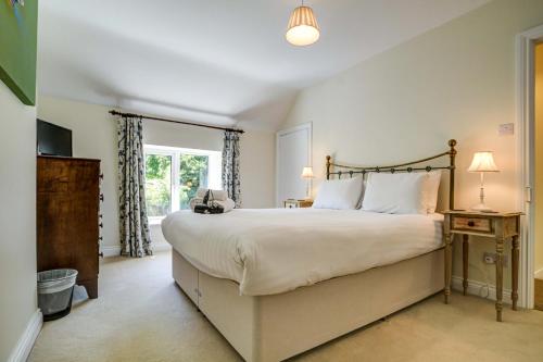 a bedroom with a large bed and a window at Rose Cottage in Adderbury