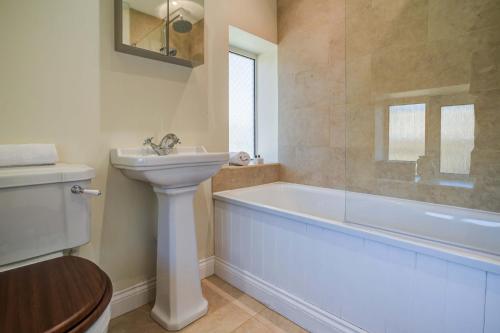 a bathroom with a tub and a sink and a toilet at Rose Cottage in Adderbury