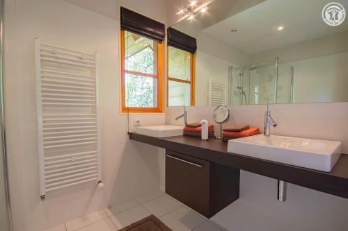 a bathroom with two sinks and a mirror at Les perrelles in Bellecombe-en-Beauges