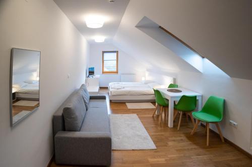 Sala de estar con sofá, cama y mesa en MERKUR APARTMENTS, en Miercurea-Ciuc