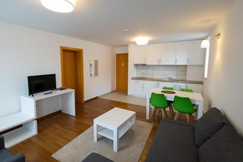 cocina y sala de estar con sofá y mesa en MERKUR APARTMENTS, en Miercurea-Ciuc