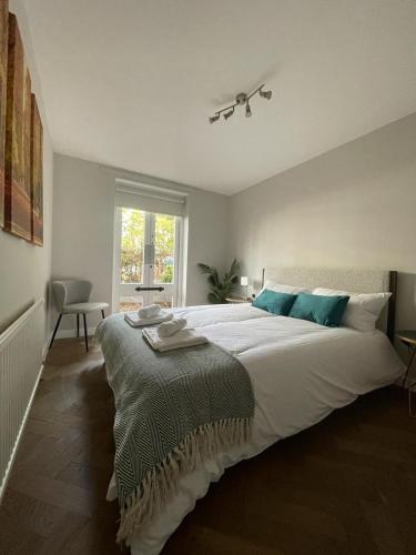 a bedroom with a large white bed with blue pillows at Tanya's Place-Stylish flat in Marylebone in London