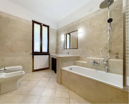 a bathroom with a tub and a toilet and a sink at Il Gatto e la Tartaruga Appartamento in Grignasco