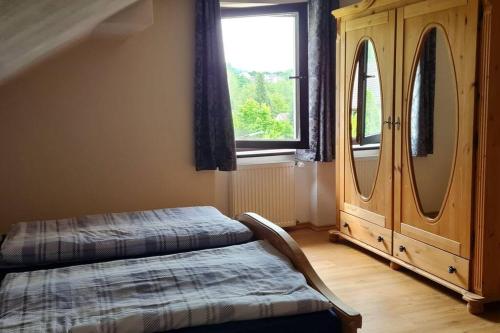 a bedroom with two beds and a dresser and a window at Ferienwohnung Casa Alotto in Windeck