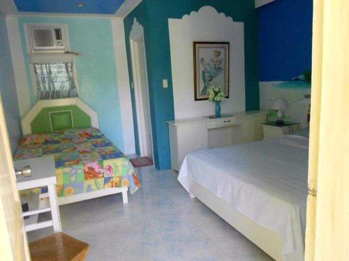的住宿－Nasan View Resort，一间卧室设有一张床和蓝色的墙壁
