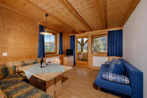 a living room with a table and a blue couch at Tendershof Reschen in Resia