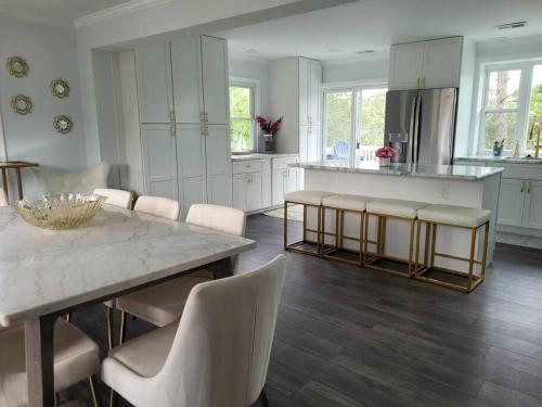 cocina con mesa, sillas y barra en Serene 5 Bedroom Waterfront Retreat Near BWI en Glen Burnie