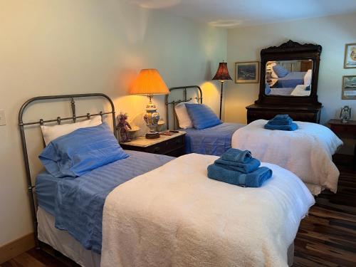 - 2 lits dans une chambre avec des serviettes bleues dans l'établissement French Woods Farmhouse Bed & Breakfast, à Hancock