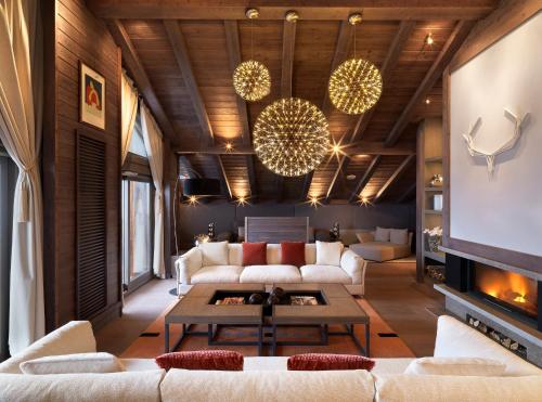 a living room with white couches and a tv at Six Senses Residences & Spa Courchevel in Courchevel
