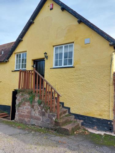 a yellow house with stairs in front of it at Red Lion in Exeter
