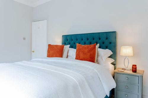 a bedroom with a large white bed with orange pillows at The Harrogate Townhouse in Harrogate