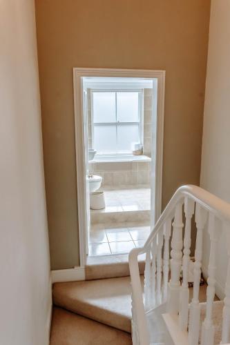 a stairway with a window and a white staircase at The Harrogate Townhouse in Harrogate