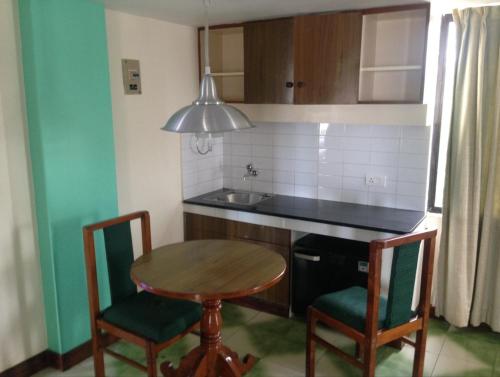 a kitchen with a table and chairs and a sink at Swagath Holiday Resort in Trivandrum