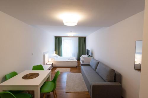 a living room with a couch and a bed at MERKUR APARTMENTS - SELF CHECK-in in Miercurea-Ciuc