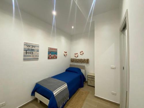 a bedroom with a blue bed in a white room at Casa Antinoro in Ustica