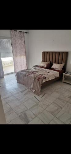 a bedroom with a bed and a tiled floor at Appartement panorama in Tunis