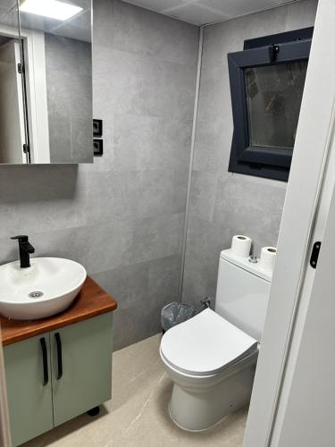 een badkamer met een wit toilet en een wastafel bij OFURO WORLD HOTEL SPA in Izmir