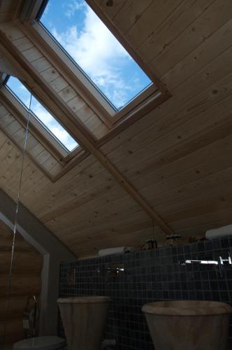 a bathroom with two sinks and a skylight at Cabana Deac - Luxury Chalet in Vatra Dornei