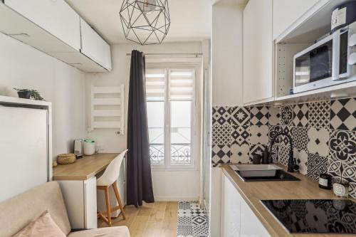 une cuisine avec une table et un comptoir dans l'établissement Small comfortable studio near Eiffel Tower, à Paris