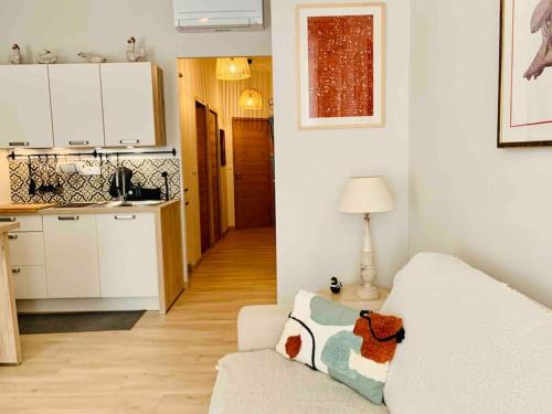 a living room with a white couch and a kitchen at JoliJoliette, terrasse, central, climatisé, WIFI , garage in Marseille