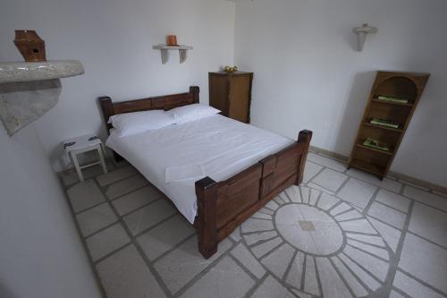 a bedroom with a large bed with white sheets at Mountain Cottage Mons Baebius in Starčevića Podi