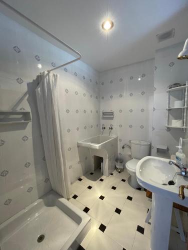 biała łazienka z umywalką, wanną i toaletą w obiekcie LAS LANZAS w mieście Sabiote