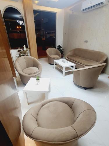 a living room with chairs and a couch and tables at دانة الفخامه للشقق الخدومة in Tabuk