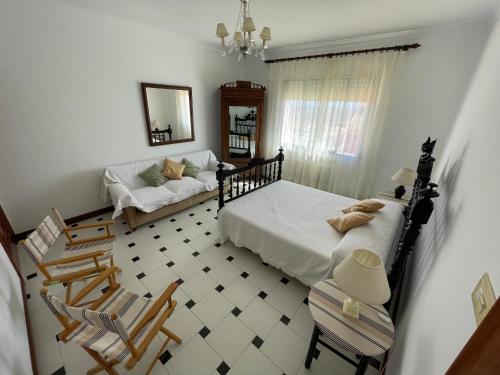 a bedroom with a bed and chairs and a couch at LAS LANZAS in Sabiote