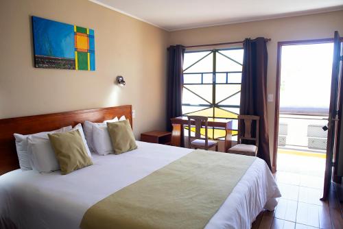 a bedroom with a large bed and a balcony at Hotel FK Paso de los Toros - Hotel Boutique in Santa Isabel