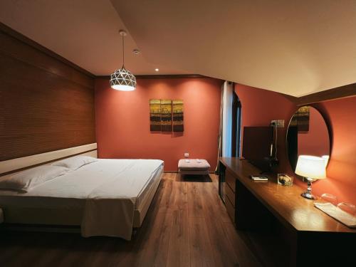 a bedroom with red walls and a bed and a television at Chateau Fasel in Tirana