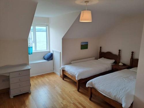 a small bedroom with two beds and a window at Buncronan Port Self Catering in Donegal