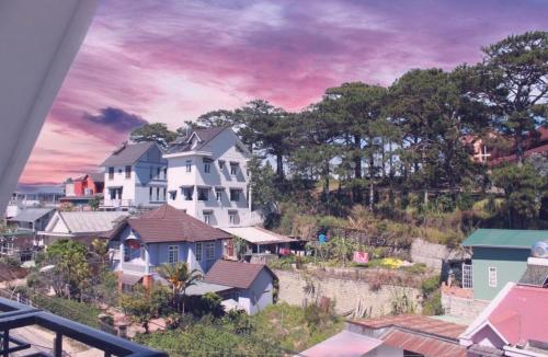 una gran casa blanca en una colina con casas en Mây's House - Nhà của Mây, en Da Lat