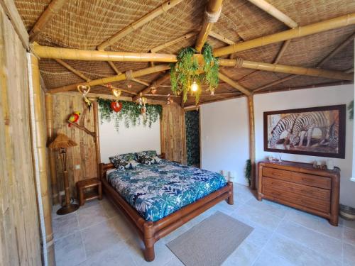 a bedroom with a bed and a wooden ceiling at Mas des rochers - Case bambou in Le Beausset