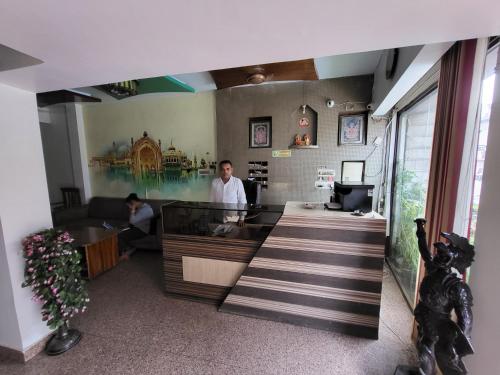 a man standing at a counter in a restaurant at Hotel Atithi Residency in Lucknow